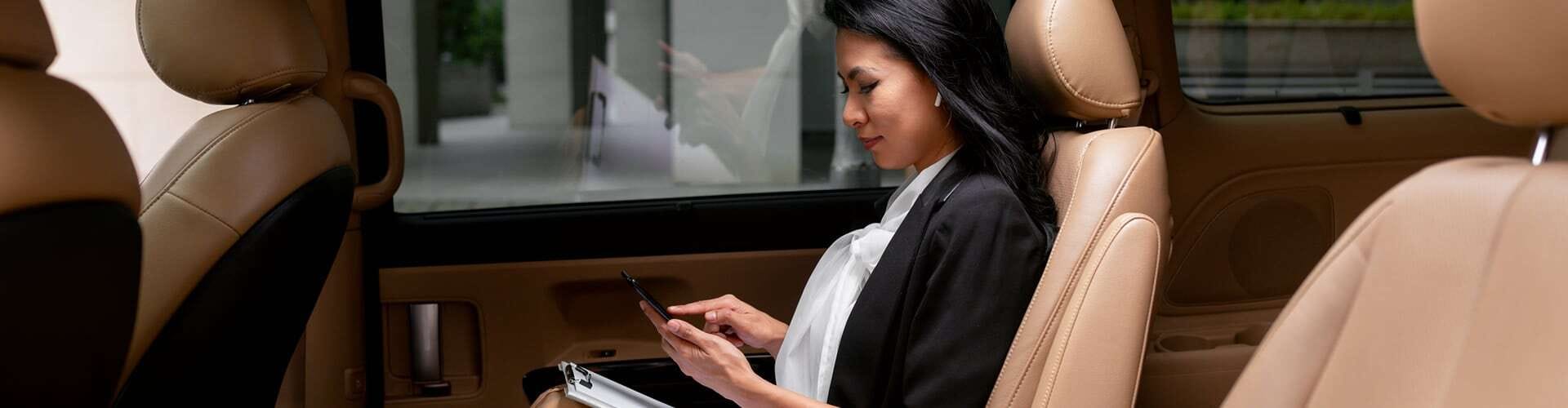 Foto di una donna elegante seduta sul sedile posteriore di una vettura executive