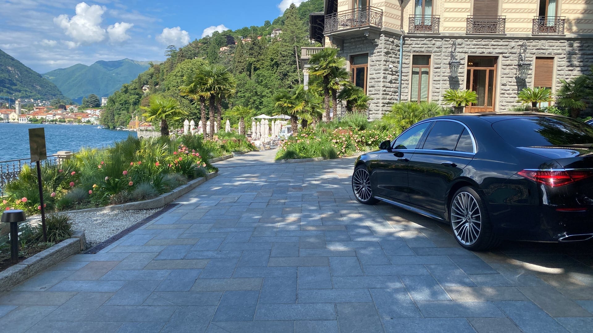 foto di macchina mercedes nera parcheggiata in un cortile di una villa